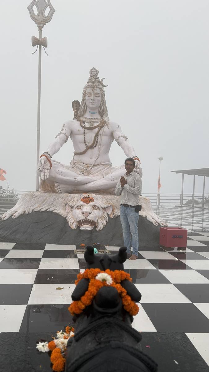 Devotee with folded hands before the Lord Shiva statue at Matogi Shiva Temple